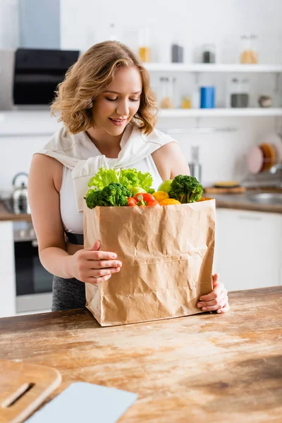 Mujer Joven Mirando Bolsa Papel Con Comestibles Cocina — Foto de Stock