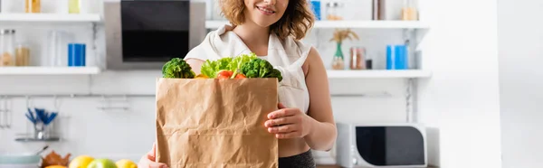 Pozioma Uprawa Młodej Kobiety Trzymającej Papierową Torbę Warzywami — Zdjęcie stockowe