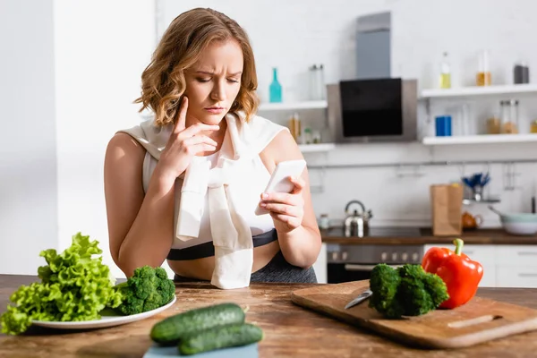 Foco Seletivo Mulher Chateada Usando Smartphone Perto Legumes Cozinha — Fotografia de Stock