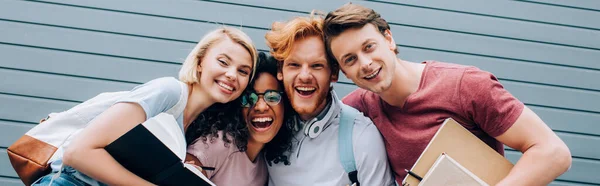 Imagen Horizontal Estudiantes Multiculturales Emocionados Mirando Cámara Mientras Sostienen Libros — Foto de Stock