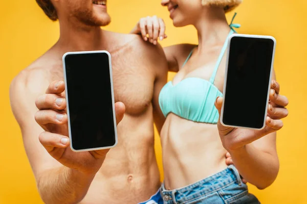 Обрезанный Вид Мужчины Женщины Рубашки Плавательном Лифчике Показывающий Смартфоны Чистым — стоковое фото
