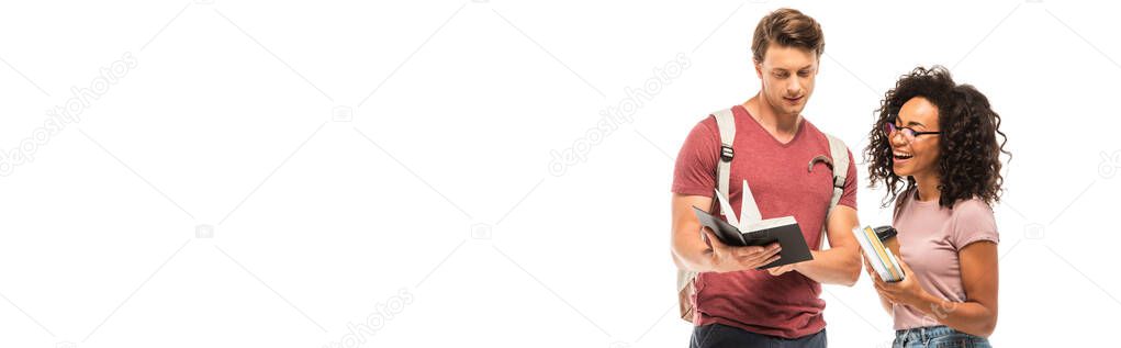 Horizontal crop of african american student holding coffee to go and books near friend with notebook isolated on white