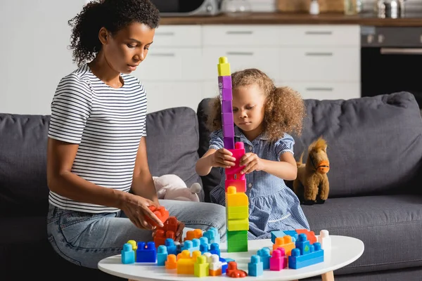 African American Kid Building Tower Multicolored Blocks While Sitting Couch — Stock Photo, Image