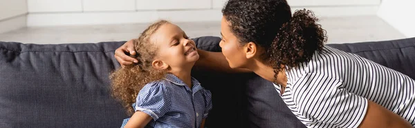 非洲裔美国妇女在家中玩乐时触摸兴奋女儿的头的全景概念 — 图库照片