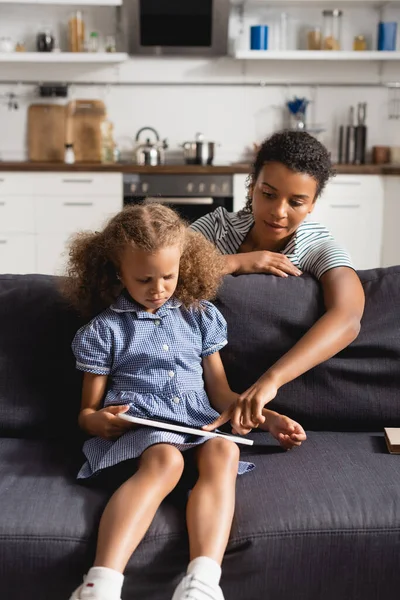 Afrikanska Amerikanska Barnflicka Röra Digital Tablett Händerna Flicka Sitter Soffan — Stockfoto