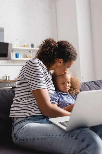 Selective Focus African American Freelancer Kissing Upset Daughter While Sitting — Stock Photo, Image