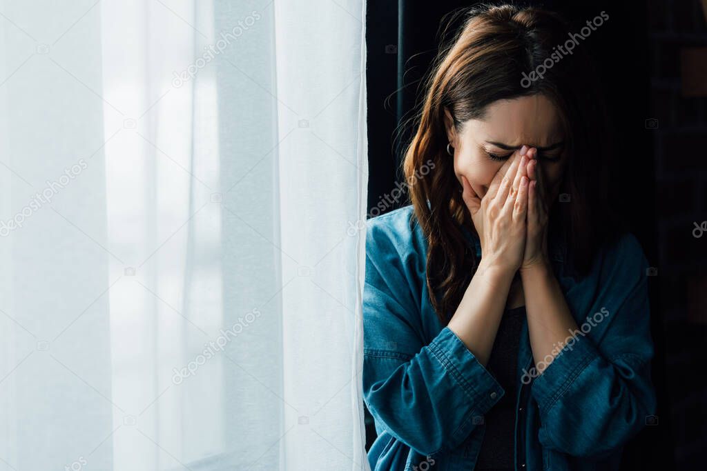 frustrated woman crying and covering face at home 