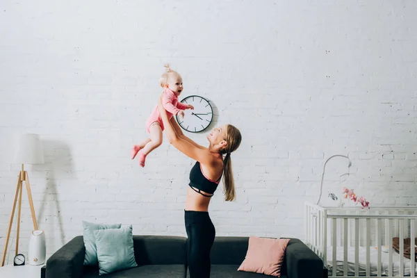 Side View Mother Sportswear Holding Daughter Home — Stock Photo, Image