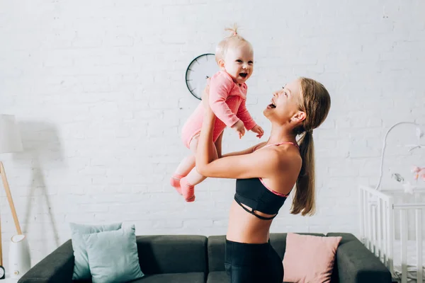 Woman Sportswear Holding Infant Girl Living Room — Stock Photo, Image