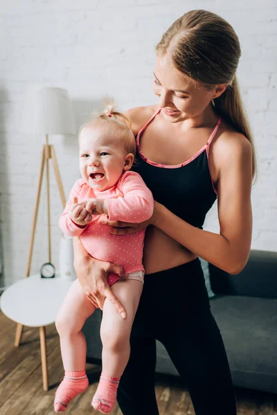 Fit Woman Holding Baby Daughter Living Room — Stock Photo, Image