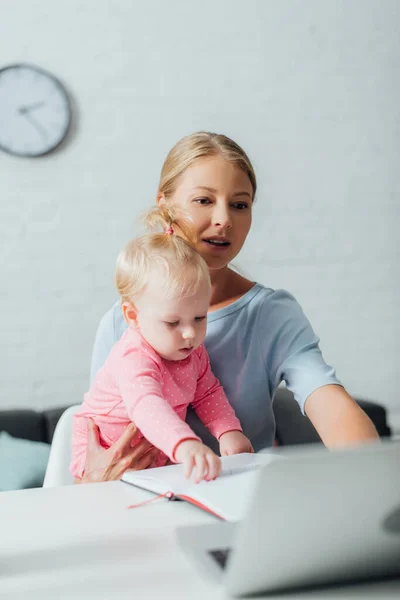 Selective Focus Woman Using Laptop While Holding Baby Daughter Home — Stock Photo, Image