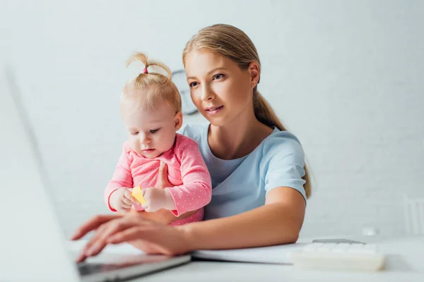 Foco Seletivo Freelancer Usando Laptop Enquanto Segura Filha Bebê Mesa — Fotografia de Stock