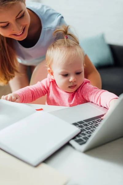 Foco Seletivo Bebê Tocando Laptop Perto Mãe Casa — Fotografia de Stock