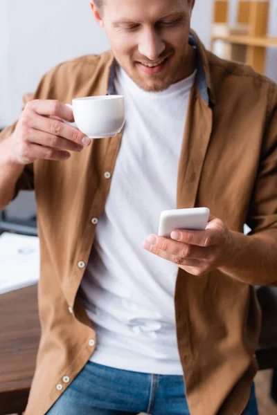 Pengusaha Dalam Pakaian Santai Mengobrol Smartphone Sambil Memegang Secangkir Kopi — Stok Foto