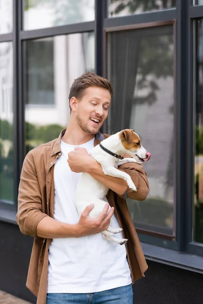 Młody Człowiek Ubraniach Casual Gospodarstwa Jack Russell Terrier Pies Ulicy — Zdjęcie stockowe