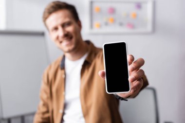 Ofiste boş ekranlı akıllı telefon gösteren işadamlarının seçici odak noktası 