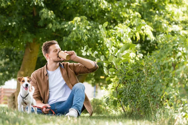 Mann Freizeitkleidung Trinkt Coffee Während Auf Rasen Neben Jack Russell — Stockfoto