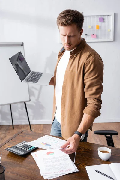 Selective Focus Young Businessman Looking Paperwork Holding Laptop Calculator Coffee — Stock Photo, Image