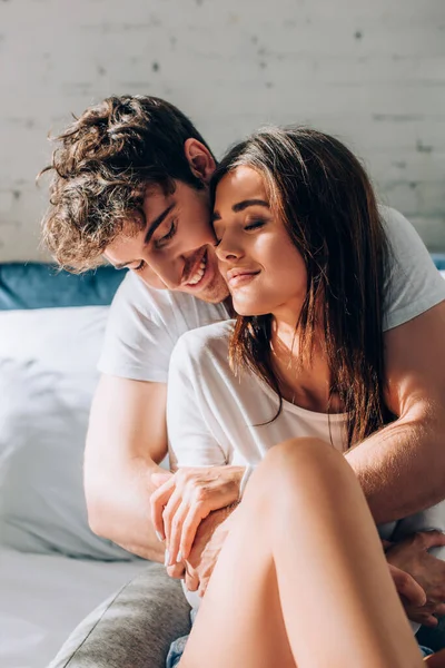 Young Man Sitting Bed Embracing Girlfriend — Stock Photo, Image