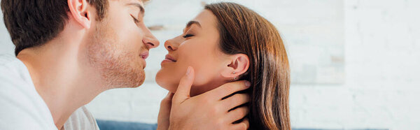 Horizontal crop of man kissing woman at home 