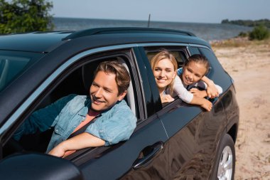 Selective focus of family traveling in car on seaside at daytime  clipart