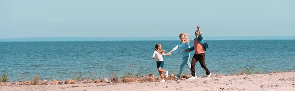 Panoramiczne Ujęcie Rodziny Córką Biegającą Plaży Pobliżu Morza — Zdjęcie stockowe