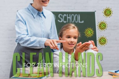 Öğretmen, okullu kızın yanındaki dezenfektanla işaret etti. Sınıfta hiç enfeksiyon belirtisi yok. 