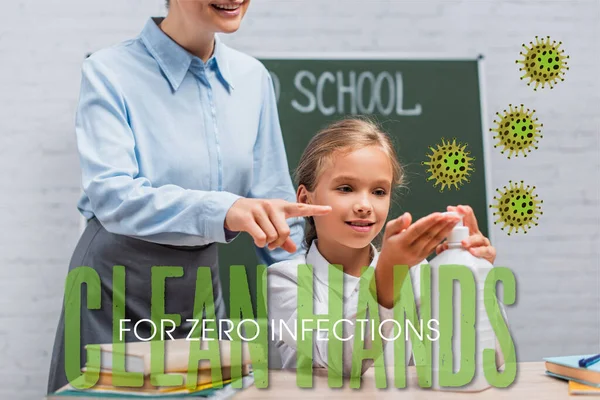 teacher pointing with finger at sanitizer near schoolgirl and clean hands for zero infections lettering in classroom