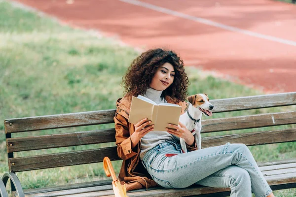 Stylish Woman Reading Book While Sitting Bench Park Jack Russell — Stock Photo, Image