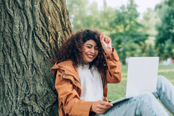 穿着秋季服装的女性在公园使用笔记本电脑的选择性焦点 — 图库照片