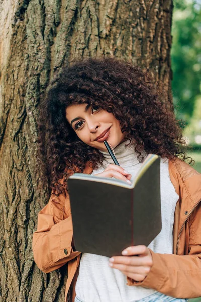 Selective Focus Young Woman Raincoat Holding Pen Notebook While Looking — Stock Photo, Image