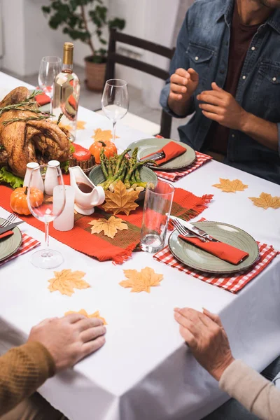 テーブルに座っている親と息子のクロップドビューは感謝祭の夕食を提供し — ストック写真