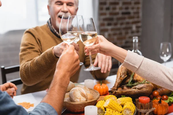 感恩节大餐期间 一家人在酒杯中碰杯白葡萄酒 — 图库照片