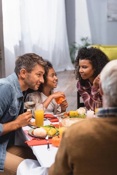 多民族の両親と感謝祭の夕食の近くにカボチャを保持するアフリカ系アメリカ人の子供の選択的な焦点 — ストック写真