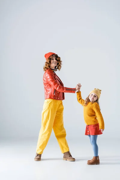 Mother Daughter Colorful Red Yellow Outfits Holding Hands Grey Background — Stock Photo, Image