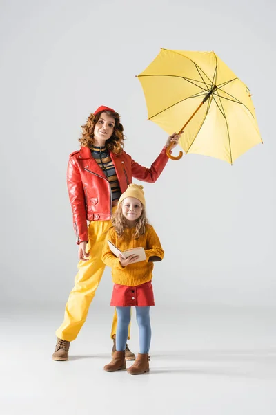Mother Daughter Colorful Red Yellow Outfits Umbrella Book Grey Background — Stock Photo, Image