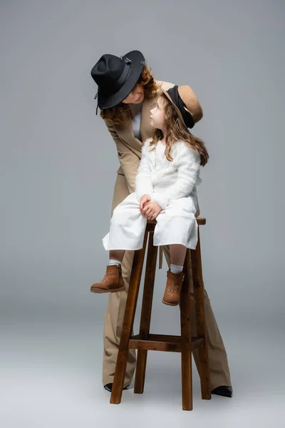 Elegante Madre Posando Cerca Hija Silla Gris — Foto de Stock