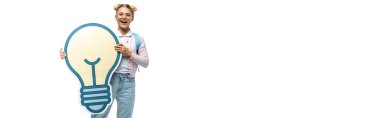 panoramic orientation of excited schoolgirl holding paper cut light bulb while looking at camera isolated on white clipart