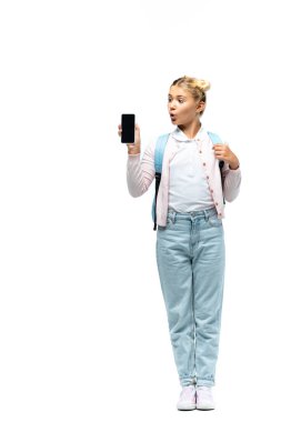 Heyecanlı okul çocuğu beyaz arka planda akıllı telefona bakıyor.