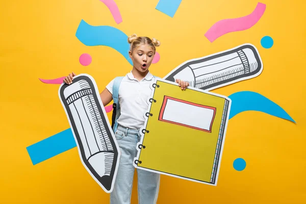 Shocked Schoolchild Holding Paper Notebook Pencil Yellow Background — Stock Photo, Image