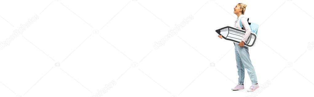 Panoramic shot of schoolgirl in eyeglasses holding paper pencil on white background