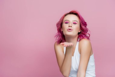 young woman with colorful hair blowing kiss isolated on pink clipart