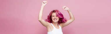 young woman with colorful hair rejoicing isolated on pink, panoramic shot clipart