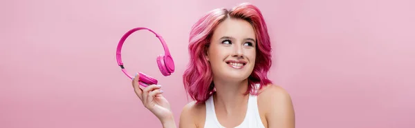 Mladá Žena Barevnými Vlasy Drží Sluchátka Usmívá Izolovaně Růžové Panoramatický — Stock fotografie