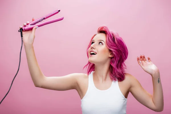 Jonge Vrouw Met Kleurrijk Haar Zoek Naar Stijltang Geïsoleerd Roze — Stockfoto