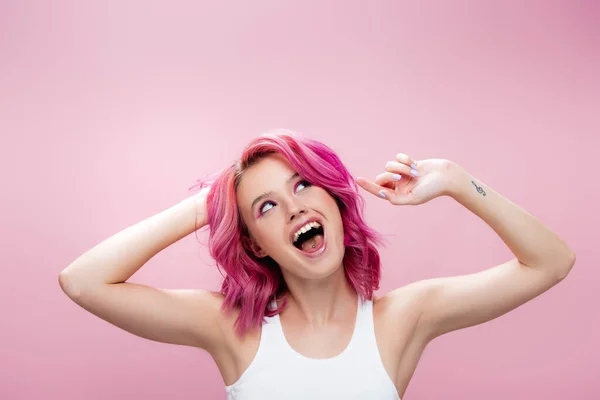 Podekscytowany Młoda Kobieta Dotykając Kolorowe Włosy Odizolowane Różowy — Zdjęcie stockowe