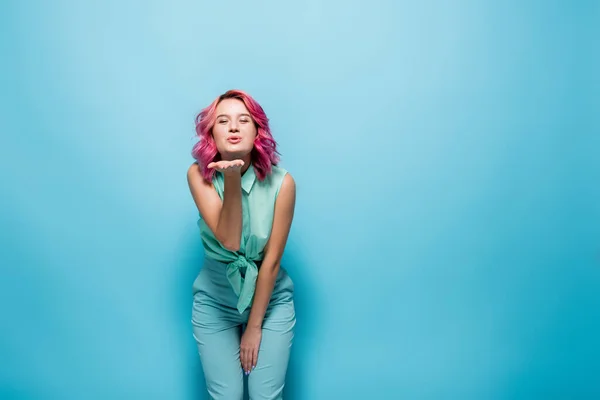 Jovem Mulher Com Cabelo Rosa Soprando Beijo Fundo Azul — Fotografia de Stock