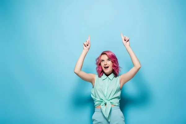 Збуджена Молода Жінка Рожевим Волоссям Вказує Синій Фон — стокове фото