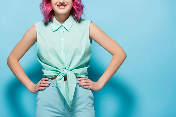 粉红头发 双手放在屁股上蓝色背景的年轻女子的剪影 — 图库照片