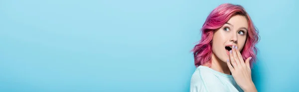 Šokovaná Mladá Žena Růžovými Vlasy Zakrývající Ústa Modrém Pozadí Panoramatický — Stock fotografie